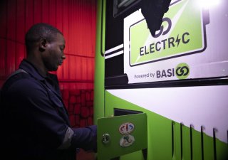 Pracovník nabíjí elektrický autobus společnosti BasiGo poháněný na nabíjecí stanici v Kigali, Rwanda, 19. března 2024.