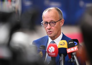 Německý kancléř Friedrich Merz hovoří s novináři při příjezdu do budovy Evropské rady v Bruselu na summit EU ve čtvrtek 15. října 2026.