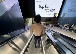 Londýnské metro v parný den. Někteří cestující volí hodně uvolněný dress code