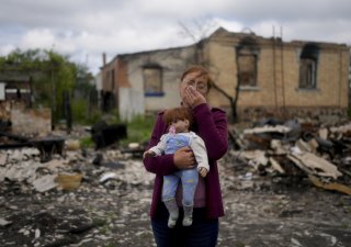 Žena u rozbombardovaného domova