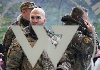 Návštěvníci ve vojenské kamufláži stojí u vchodu do „PMC Wagnerova centra“, které je spojeno s podnikatelem a zakladatelem soukromé vojenské skupiny Wagner Jevgenij Prigožin, během oficiálního otevření kancelářského bloku během Dne národní jednoty v St. Petersburg, Rusko, 4. listopadu 2022.