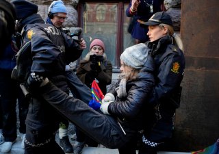Policisté odnášející Gretu Thunbergovou protestující s dalšími ekology před norským ministerstvem financí v Oslu pro záchranu sobů.