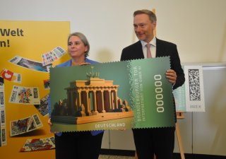 Nikola Hagleitnerová z vedení pošty a spolkový ministr financí Christian Lindner se zobrazením digitální verze známky