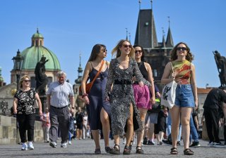 Turistiky se procházejí po Karlově mostě v Praze