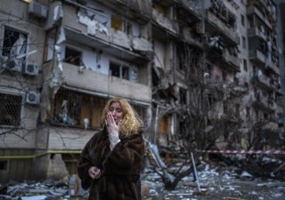Jedna z obyvatelek Kyjeva před domem, v němž bydlela, zničeném po ruském raketovém útoku.