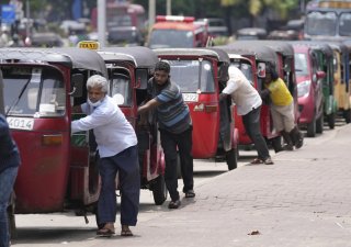 Srílanští řidiči tlačí své rikši k čerpací stanici