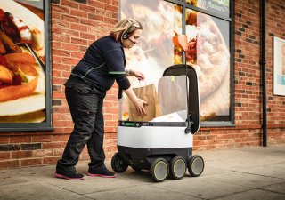 Prodavačka ukládá objednaný nákup do doručovacího robotu.