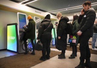 Menschen versuchen, an einem Geldautomaten in St. Petersburg Geld abzuheben