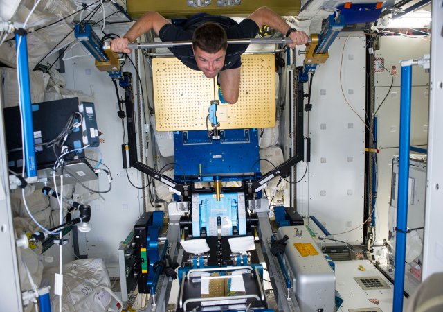 Astronaut Reid Wiseman při jeho vesmírném "workoutu"