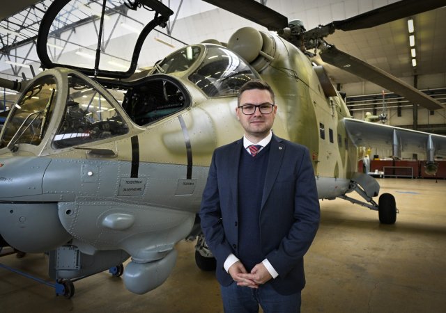 Jiří Protiva, ředitel LOM Praha. Na pozadí bitevní vrtulník Mi-24D