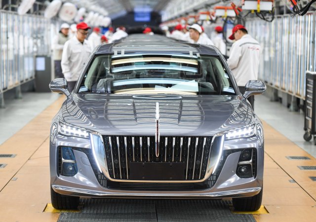 Zaměstnanci kontrolují smontované vozy v dílně automobilky FAW