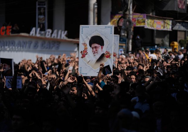 dav protestující proti úderům USA a Izraele na Írán s portrétem ajatoláha Chameneího