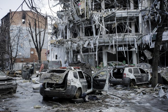 Obytný dům a auta po ruském útoku 16. března 2022 na ukrajinský Charkov.
