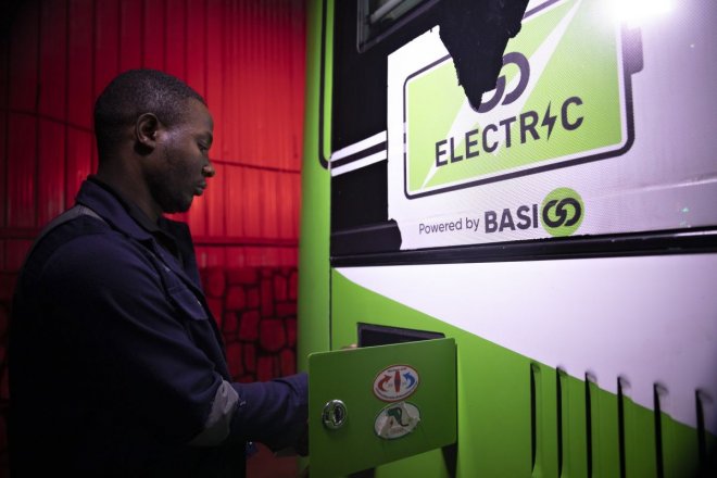 Pracovník nabíjí elektrický autobus společnosti BasiGo poháněný na nabíjecí stanici v Kigali, Rwanda, 19. března 2024.