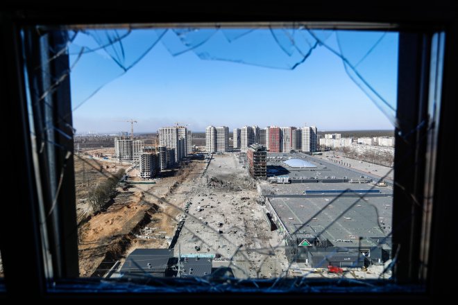 Výhled z rozbitého okna na ruským útokem zničené nákupní centrum v Kyjevě, 21. března.