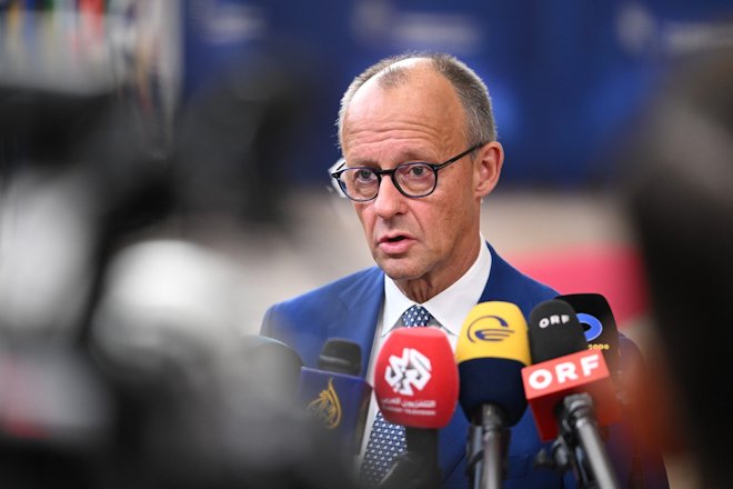 Německý kancléř Friedrich Merz hovoří s novináři při příjezdu do budovy Evropské rady v Bruselu na summit EU ve čtvrtek 15. října 2026.