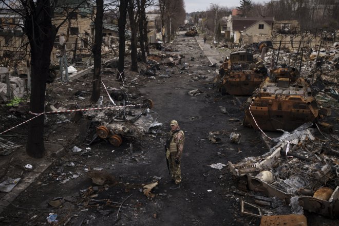 Ukrajinský muž stoj na ulici poseté zničenými ruskými tanky v městě Buča, kde se Rusové podle očitých svědků i západních médií a vlád dopustili zabíjení civilistů a válečných zločinů, 6. dubna 2022.