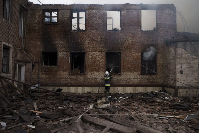 Hasiči likvidují požár ve zničené škole v Charkově 12. dubna 2022.