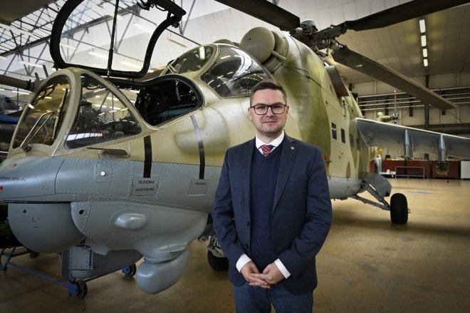 Jiří Protiva, ředitel LOM Praha. Na pozadí bitevní vrtulník Mi-24D