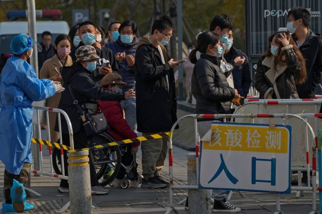 Lidé v Číně čekají na každodenní pravidelné testování na covid.