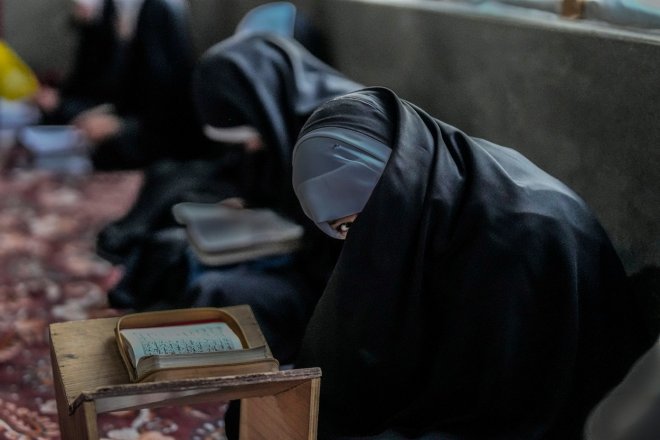 Kašmírská muslimská dívka pozoruje fotoaparát při své návštěvě hodiny recitace Koránu během postního měsíce ramadánu ve Šrínagaru na území Kašmíru ovládaného Indií v neděli 26. března 2023. Muslimové po celém světě nyní dodržují svatý postní měsíc ramadán.