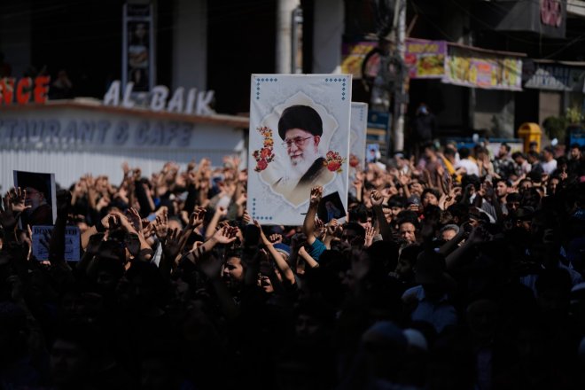 dav protestující proti úderům USA a Izraele na Írán s portrétem ajatoláha Chameneího