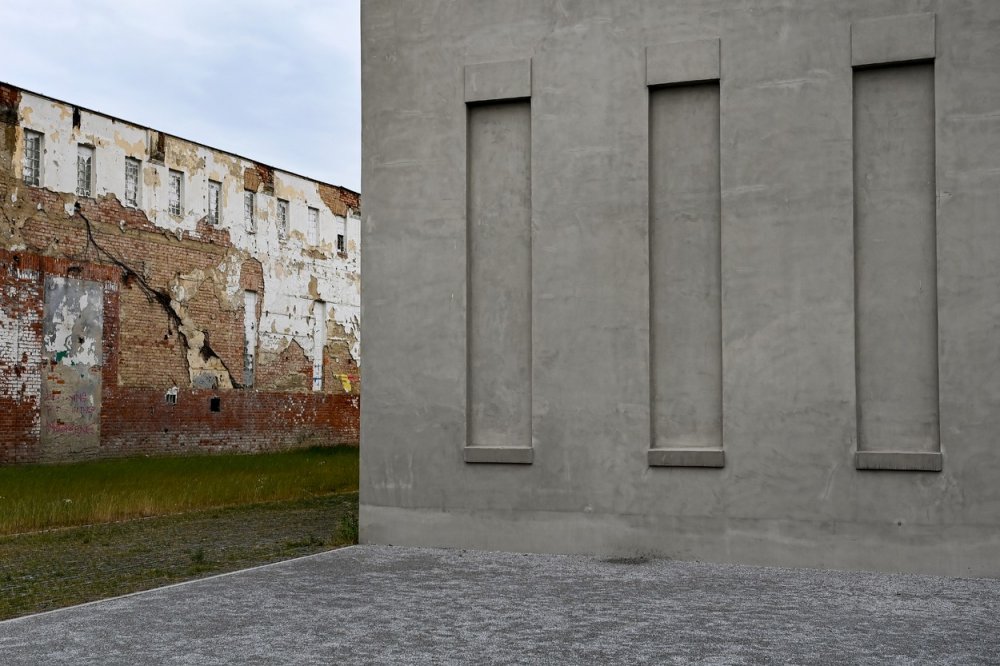 Stěny jatek byly zchátralé a probourané obrovskými otvory. Cihlové zdivo zčernalé sazemi svědčilo o průmyslové historii města. 