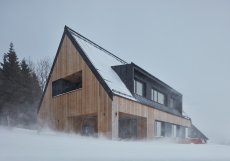 Architekti měli pro rodinu s dvěma dětmi navhnout chatu, která zapadne do krajiny, bude respektovat místní architekturu a zároveň i působit moderním dojmem.