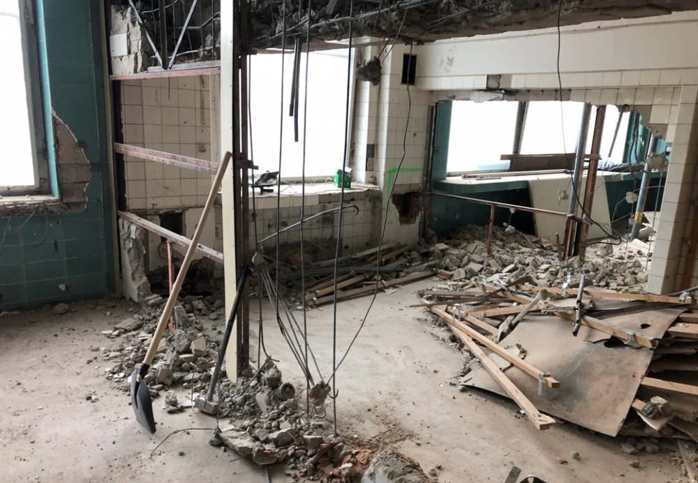 Pohled na rozbitou zeď dělící prostor operačního sálu, instrumentárny a druhého z operačních sálů ve 4. patře pravé části nemocničního objektu. Výrazné prosklení je dodnes zachováno a je patrné i při pohledu zvenčí.