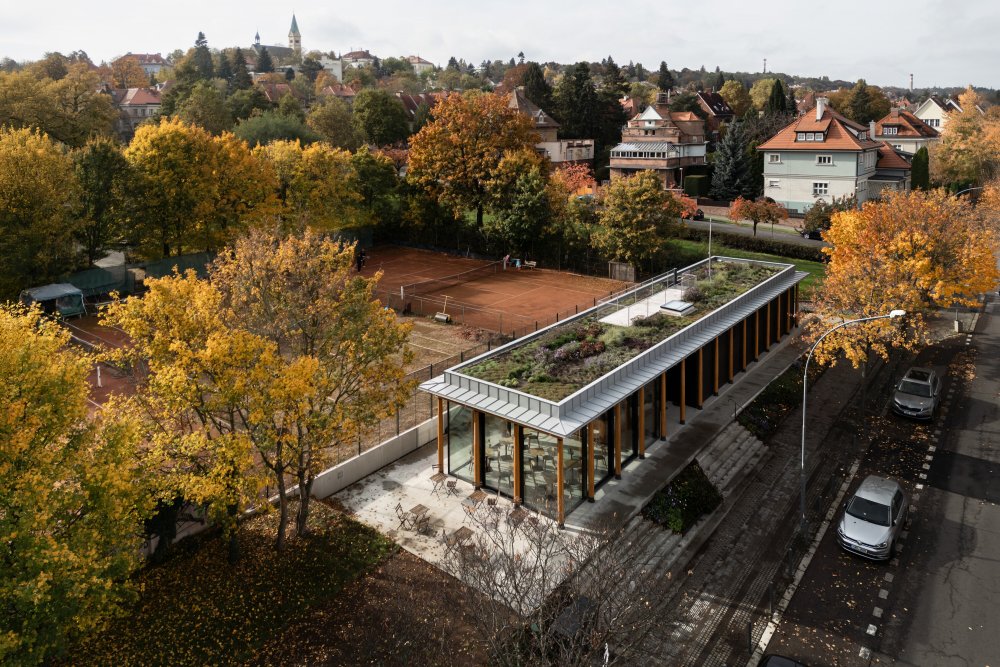 Dřevostavba, která klubovnu tvoří je záměrně lehká a vystavěná na sloupech jako zahradní pavilon uprostřed parku. Svým výrazem evokuje lázeňské altány a kolonády spojené s relaxací a klidem. 