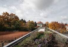 Dřevostavba, která klubovnu tvoří je záměrně lehká a vystavěná na sloupech jako zahradní pavilon uprostřed parku. Svým výrazem evokuje lázeňské altány a kolonády spojené s relaxací a klidem. 
