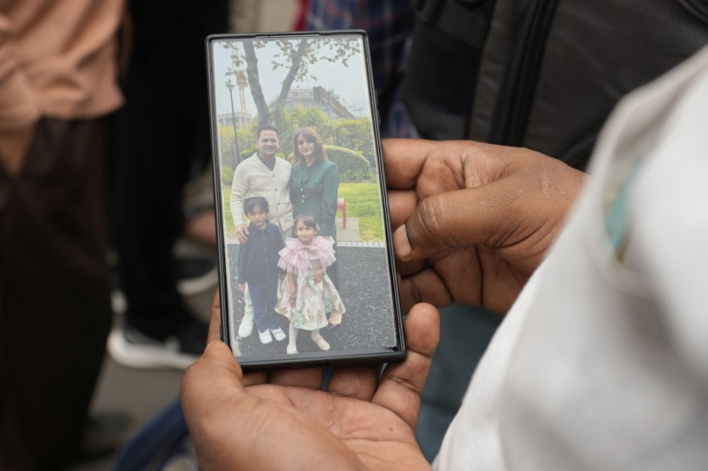 Jeden z příbuzných obětí ukazuje na svém mobilním telefonu fotografii svého synovce a jeho rodiny, kteří zahynuli při letecké havárii letadla společnosti Air India.