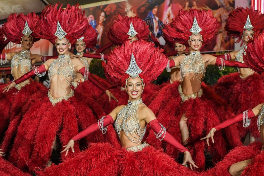 Lopatky červeného větrného mlýna na kabaretu Moulin Rouge v Paříži se roztočily ve čtvrtek večer. Událost oslavily desítky slavnostně oděných tanečnic před objektem tancem kankánu.