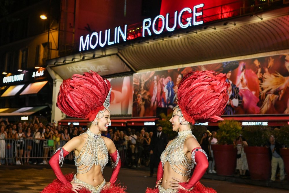 Lopatky červeného větrného mlýna na kabaretu Moulin Rouge v Paříži se roztočily ve čtvrtek večer. Událost oslavily desítky slavnostně oděných tanečnic před objektem tancem kankánu.