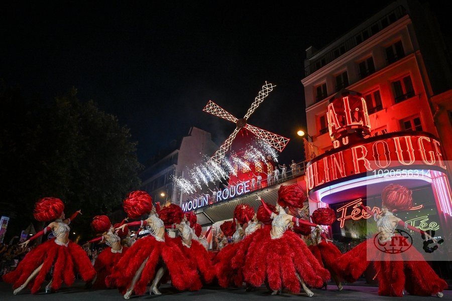 Lopatky červeného větrného mlýna na kabaretu Moulin Rouge v Paříži se roztočily ve čtvrtek večer. Událost oslavily desítky slavnostně oděných tanečnic před objektem tancem kankánu.