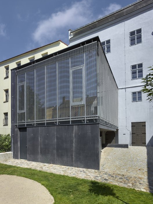 Dům se nachází na spodní straně hlavního Masarykova náměstí v Jihlavě. Jedná se o urbanisticky i architektonicky hodnotný objekt pod památkovou ochranou. Je typickým příkladem měšťanského domu na jihlavském náměstí, které představují nejhonosnější stavby svého druhu u nás. Obnova nevyužívaného domu byla spojena s nalezením vhodného využití, založeném na zájmu o životaschopnost a zpřístupnění velmi cenné architektonické památky veřejnosti.