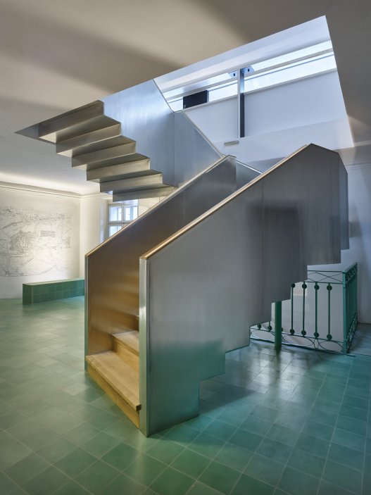 Dům se nachází na spodní straně hlavního Masarykova náměstí v Jihlavě. Jedná se o urbanisticky i architektonicky hodnotný objekt pod památkovou ochranou. Je typickým příkladem měšťanského domu na jihlavském náměstí, které představují nejhonosnější stavby svého druhu u nás. Obnova nevyužívaného domu byla spojena s nalezením vhodného využití, založeném na zájmu o životaschopnost a zpřístupnění velmi cenné architektonické památky veřejnosti.