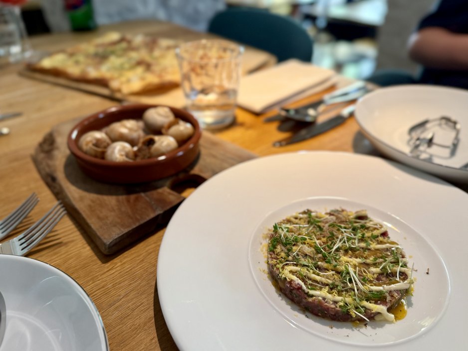 Předkrmy na stole – šneci, tarte flambée a hovězí tatarák s uzenou majonézou a lanýžovým žloutkem