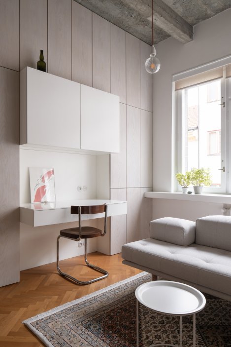  Celou jednu stěnu bytu tvoří bíle olejovaný dubový obklad skrývající úložné prostory. Je to pomyslná páteř, která drží byt pohromadě.