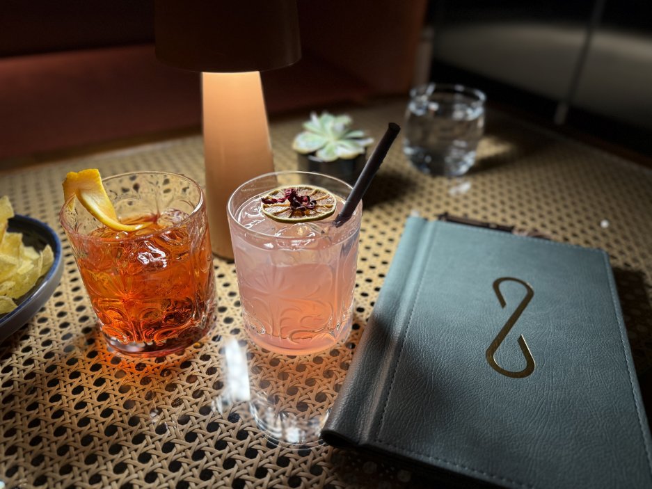 Dva koktejly z lobby baru – klasické Negroni a svěží signature drink hotelu Keight