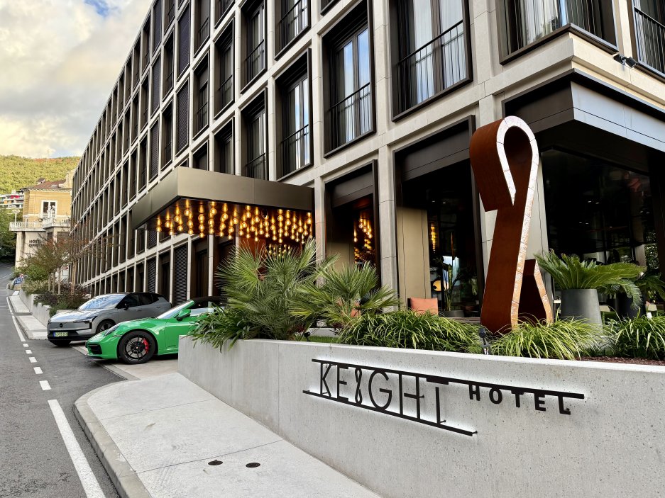 Vstupní část hotelu s dominantním logem a decentní světelnou instalací nad vchodem