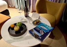 Uvítací pozornost: láhev vína, ovoce, makronky a osobní vzkaz