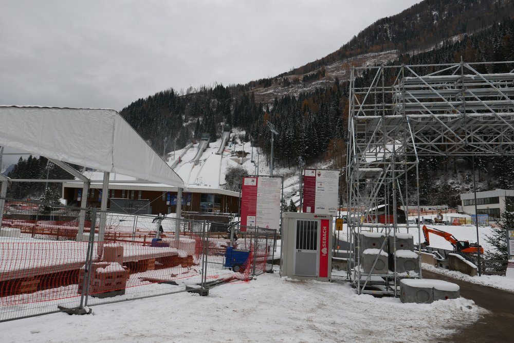 Rekonstrukce skokanského areálu v Predazzu pro Zimní olympijské hry Milano-Cortina 2026 představuje citlivý kompromis mezi sportovním prestiží, tlakem na udržitelnost a obrovskými veřejnými investicemi. Z ekonomického pohledu se projekt pohybuje v desítkách milionů eur