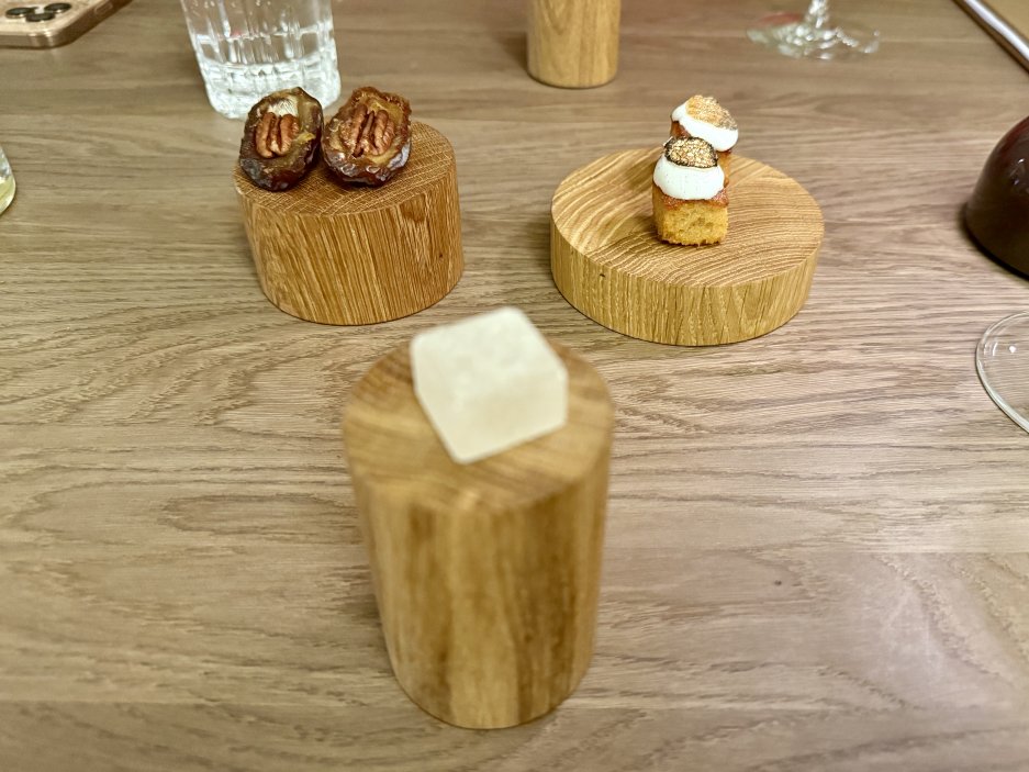 Petit fours servírované na dřevěných podstavcích jako závěr degustačního menu