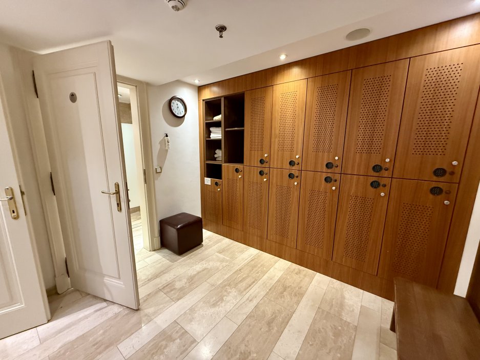 Šatny wellness a fitness centra v Mandarin Oriental, Prague. Dřevo, kámen a dostatek prostoru podtrhují klubový charakter celého zázemí