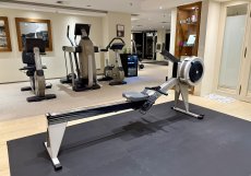 Přehled fitness prostoru s kombinací kardio strojů a funkční zóny. Dispozice je navržená spíše pro individuální trénink než pro skupinový provoz