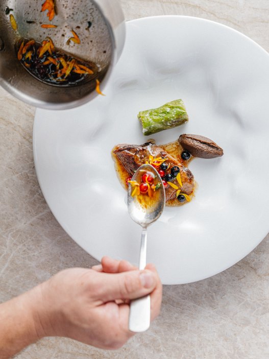 A toto je amuse bouche: Amuse bouche: brambory v popelu – křupavý košíček, bramborová pěna, uzená ryba, kefír a loupákové máslo, čerstvý kopr, pažitka, strouhaný sušený žloutek.