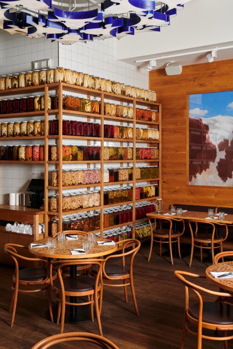 Interiér kombinuje open-kitchen design s otevřeným grilem a důrazem na kvalitu českého masa s moderním pojetím kuchyně.