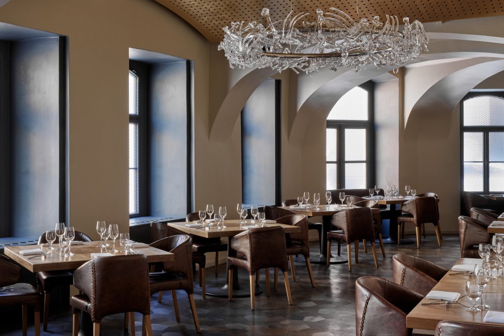 Součástí interiéru jsou autorské prvky jako výrazný křišťálový lustr „Consommé“, dubová podlaha a stolování z dubového dřeva nebo čedičové dlaždice v kuchyni.