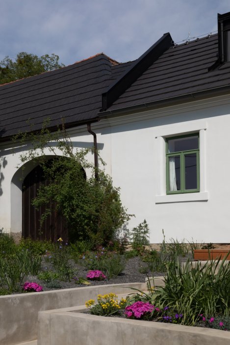 Detail vstupní fasády s tradičním členěním oken. Nové výplně respektují původní proporce, ale splňují dnešní nároky na tepelný komfort i energetickou úspornost.